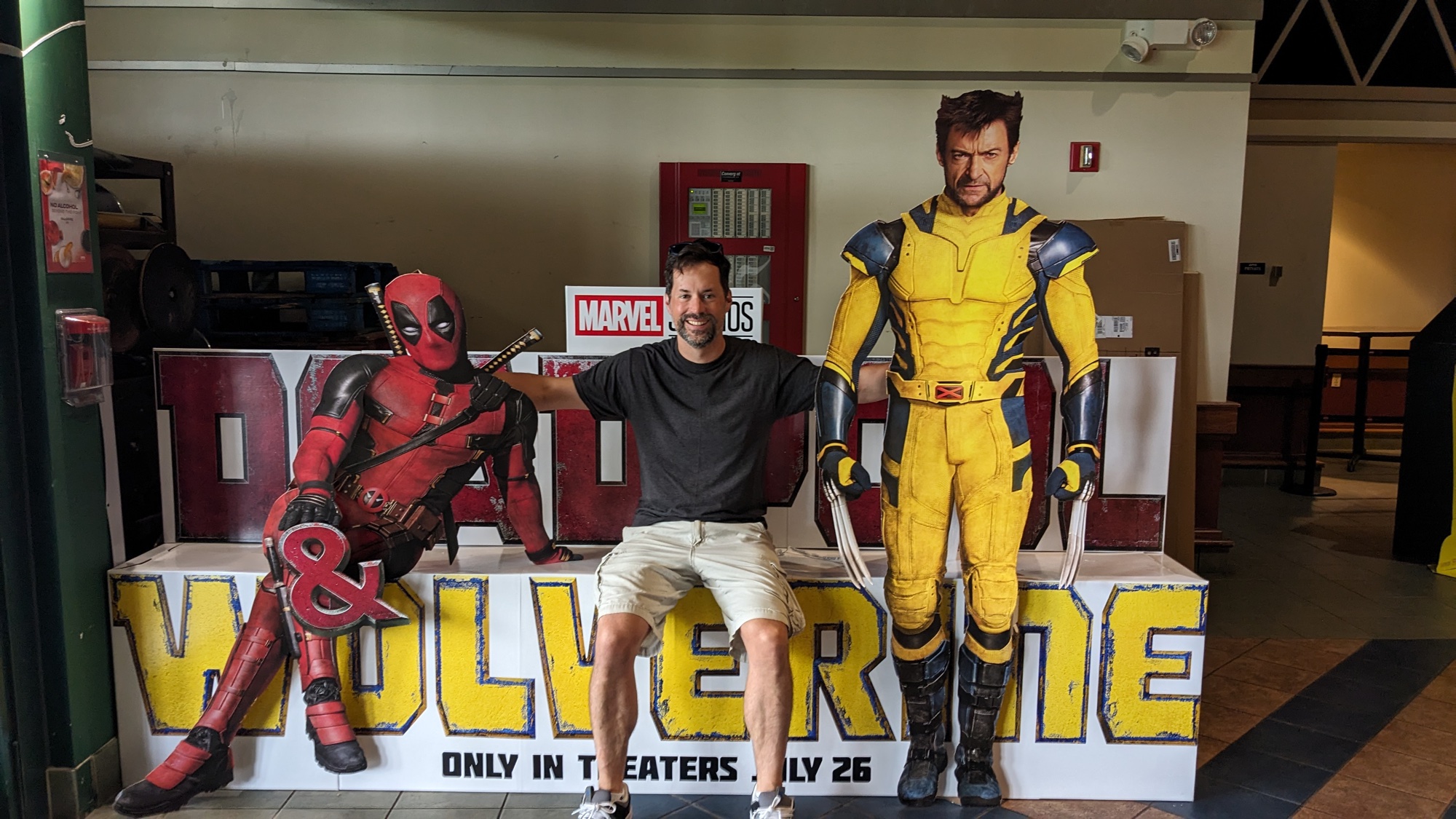 Me between the Deadpool and Wolverine standees at the theater