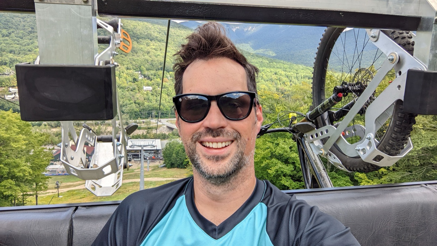 On the lift at a New Hampshire bike park, mountain bike hanging behind me